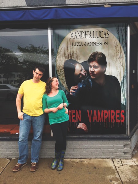 a couple standing in front of a movie poster; the girl looks adoringly at the male star while the boy looks annoyed